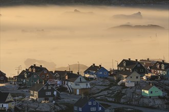 Inuit settlement in front of icebergs in the fog, midnight sun, summer, Ilulissat, Ilulissat