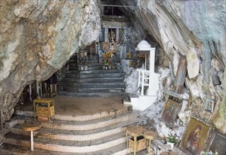 Interior view of a chapel built into the cave with steps and candles, rock church of Smerna, Church