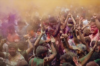 Revellers dancing in the beat of music as they celebrate Holi on a street, the Hindu spring