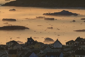 Inuit settlement in front of icebergs in the fog, midnight sun, summer, Ilulissat, Ilulissat