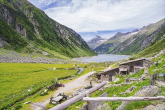 View of a mountain landscape with a lake, huts and a path through a green meadow, Klein Tibet,