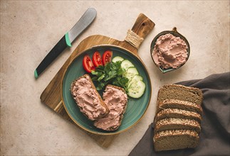 Liver meat pate spread on rye bread, breakfast, close-up, beige background. no people, selective