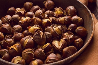 Roasted chestnuts, in an iron pan, wooden table, top view, no people, rustic style