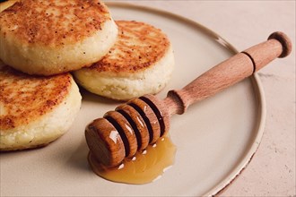 Cottage cheese pancakes, with honey, close-up, on a beige table, selective focus, no people