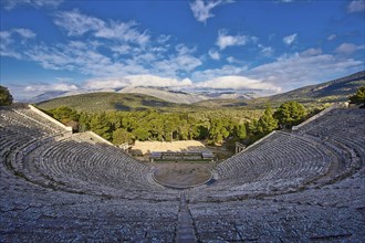 Wide view over an ancient amphitheatre with dynamic shadows and mountain panorama, Ancient