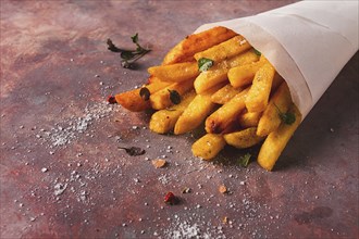 Fried French fries, in a paper bag, on an abstract background, no people, rustic