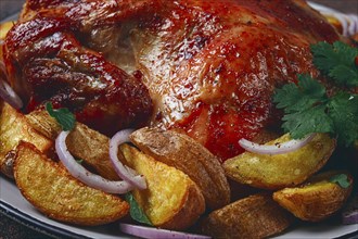 Fried, baked chicken, in the oven, with spices, and rustic potatoes, top view, homemade