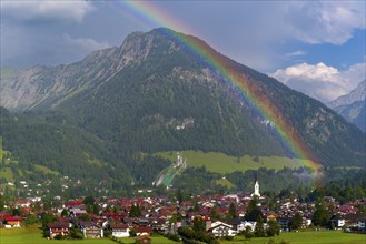 View over Oberstdorf with rainbow, behind it the Schattenberg, 1845m, OberallgÃ¤u, Bavaria,