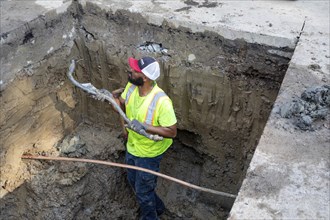 Detroit, Michigan, A workers holds a piece of an old lead water service line that is being replaced