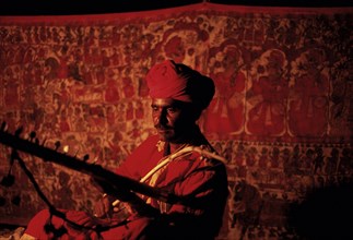 Hindu man playing music, Pabuji bhopa playing ravanhatha, Rajasthan, India. The Bhopa caste is a