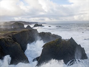 Large Atlantic storm waves crashing onto jagged rocky coast at Hartland Quay, north Devon, England,