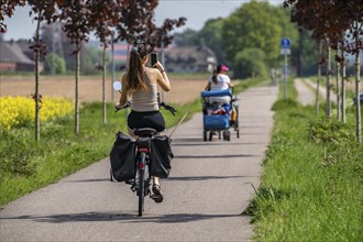 Cyclist on the avenue cycle path between Xanten and Marienbaum, Kalkar, mobile phone photo during