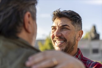 Close-up of a happy married gay couple looking to each outdoors