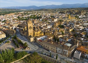 Aerial view of a city with historic church in the centre, surrounded by buildings and landscape,