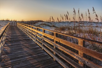 Sunset view of boardwalk over sand dunes in Gulf Shores Alabama protects sand dunes from erosion