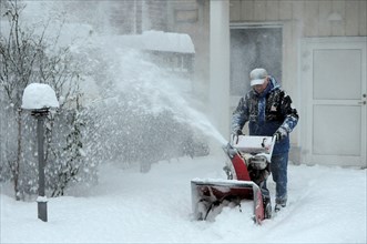 Man with snowblower clearing snow, Ystad, Scania, Sweden, Scandinavia, Europe