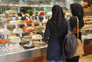 Two woman looking at cakes in a pastry shop, Barbol, Iran, 18/05/2016, Asia