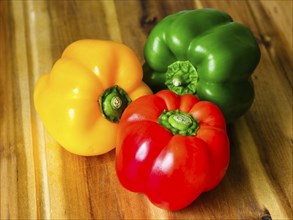 Close-up, yellow, red, green peppers (Capsicum annuum) on wooden board