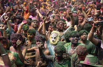 Revellers dancing in the beat of music as they celebrate Holi on a street, the Hindu spring