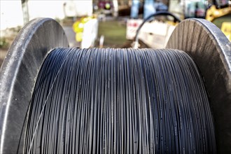 Cable drum with fibre optic cable is lying on a construction site for laying, Berlin, 29.02.2024