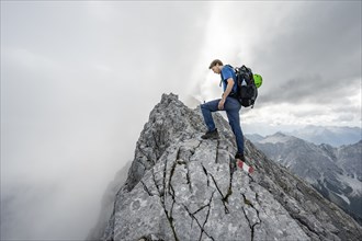 Mountaineer on a narrow rocky ridge, Watzmann crossing to Watzmann Mittelspitze, view of mountain