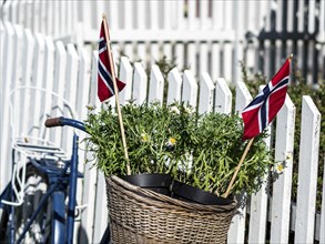 Decorated bicycle at a white fence, norwegian national day, village Solvorn at the Sognefjord,