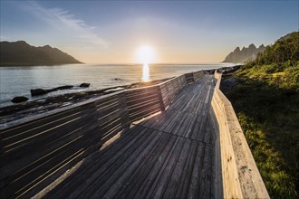 Coast at Tungeneset, sunset over the fjord, wooden path, view over rock formation to mountain range