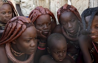 Group of Himba children and young woman look at pictures on a camera, near Opuwo, Kaokoveld,