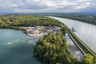 Aerial view of turquoise quarry pond of a gravel pit, excavation and loading area at the Rhine