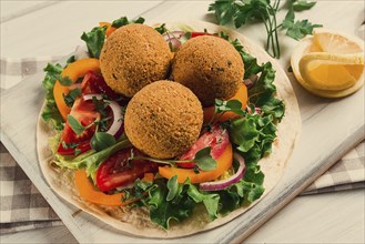 Tortillas, wrapped falafel balls, with fresh vegetables, vegetarian healthy food, on a wooden white