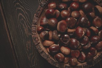 Fresh chestnuts, in a wooden bowl, top view, no people