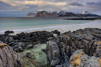 Rocky coast and beach in front of Bergen, sea, clouds, winter, Flakstadoya, Lofoten, Norway, Europe