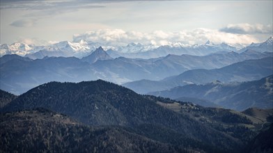 View of the Alpine foothills and main Alpine ridge with snow-covered peaks of the Zillertal Alps,