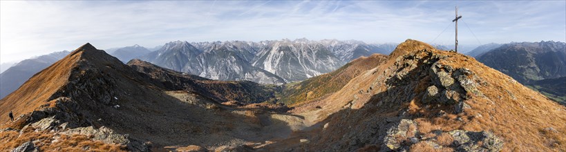 Panorama, summit cross on the ridge of the Venet, view of mountains in the Parzinn group in the