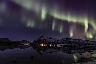 Northern lights over fjord, steep mountains, winter, aurora borealis, Flakstadoya, Lofoten, Norway,