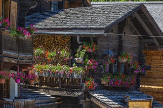 Old wooden house with wooden shingle roof and flower boxes in the historic centre of Grimentz, Val