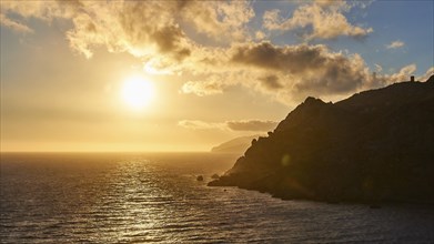 A tranquil sunset over the sea with a view of rocky cliffs, Mani Peninsula, Peloponnese, Greece,