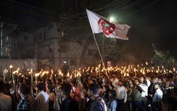 Members of the All Assam Students' Union (AASU) take part in a flaming torch rally and shout