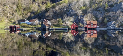 Near Ana-Sira at the norwegian southern coast, lonely houses at the foot of a rock formation are