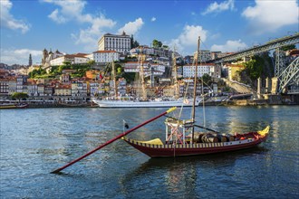 View of Porto city and Douro river with traditional boats with port wine barrels and sailing ship