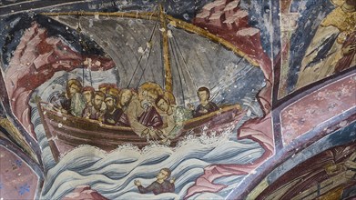 Religious fresco depicting men in a boat on a stormy sea, in a historic church, scene with the