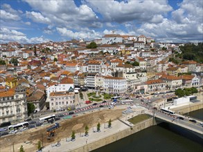 Urban landscape with many buildings and a bridge, under a cloudy sky, aerial view, Coimbra, Rio