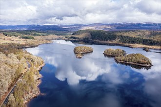 Clouds reflected in lake Loch Garry, islands on the mirrored sky, scottish highlands, aerial view,