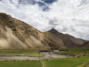 Green fields along riverbed, highlands of Tibet, China, Asia