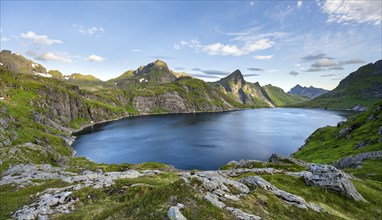 Mountain landscape with lake Tennesvatnet, at sunrise, in the back peak of Hermannsdalstinden,