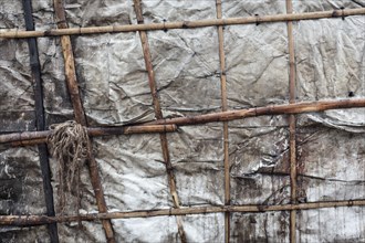 Detail of a makeshift dwelling made of plastic sheeting and bamboo sticks, Tejgaon Slum Area,