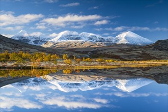 Reflection of the autumn landscape in Rondane National Park, snow-capped mountains, Doraldalen,