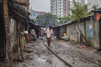 A man balances on a rail of a railway track, Tejgaon Slum Area, Dhaka, Bangladesh, Asia