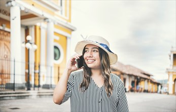 Tourist girl calling phone in the street. Happy travel woman calling on the phone in a tourist