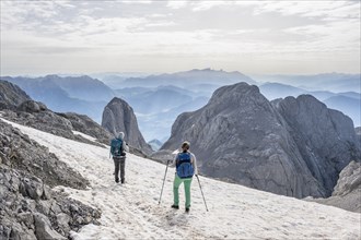 High alpine landscape, snowfields and rock, Two hikers descending from the Hochkönig, Tyrol,